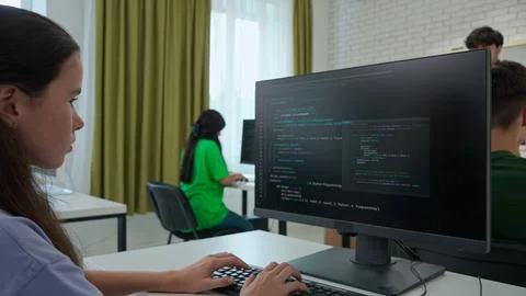 Focused Female Student Programming on Computer in Classroom Stock Photos