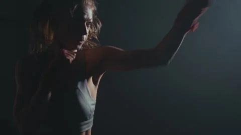 Focused fighter trains in dimly lit gym at dusk for upcoming boxing match Stock Footage 284413355