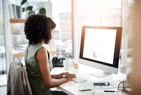 Focused on finishing her work task. a young businesswoman working at her desk in Stock Photos