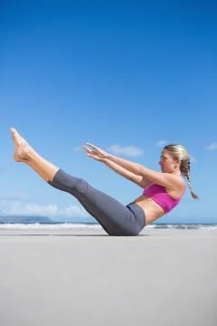Focused fit blonde doing yoga on the beach Stock Photos