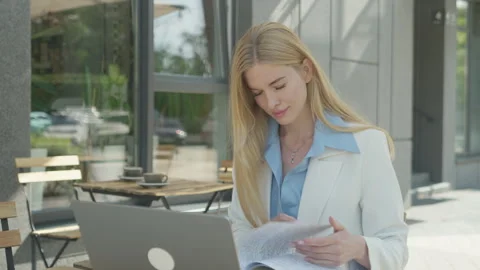 Focused Freelancer Reading Notes And Working On Laptop Outdoors Vidéo 313838933