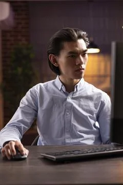 Focused freelancer scrolling through online documents on computer Stock Photos