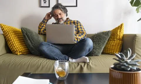 Focused freelancer working remotely from home office on laptop 스톡 사진