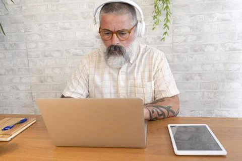Focused freelancer working remotely from home office using laptop and headp.. Stock-Fotos