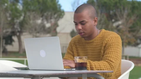 Focused freelancer working remotely on laptop at outdoor cafe Stock Footage 300334021