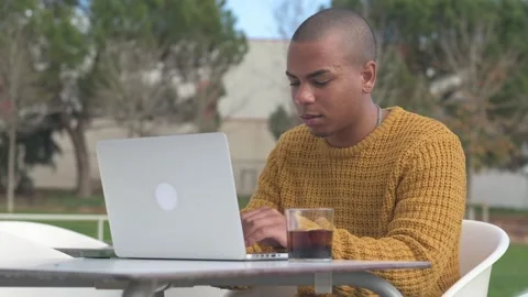 Focused freelancer working remotely on laptop in outdoor cafe Stock Footage 300437376