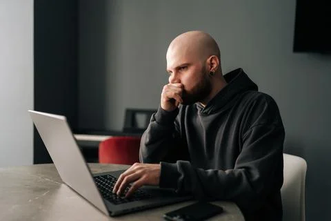 Focused freelancer young man remote working from home office, sitting at a table Stock Photos