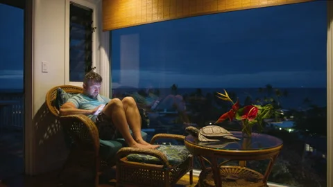 Focused guy looking at screen of tablet tech device working remotely on vacation Stock Footage 263600419