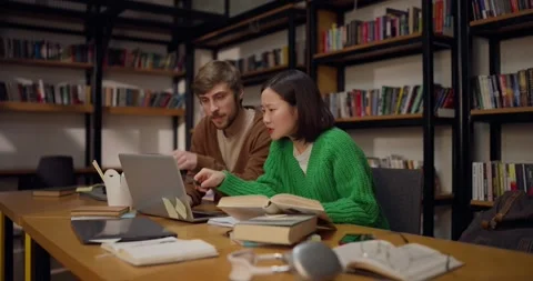Focused guy student together with his girlfriend solve a problem and come to a Vidéo 313357251