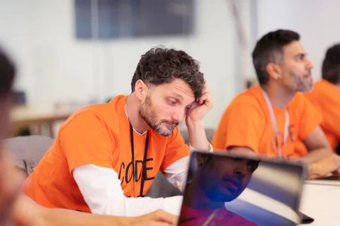 Focused hacker coding for charity at hackathon Stock Photos