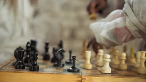 Focused Hand Strategizing Chess Move on Wooden Board Stock Footage 317695819