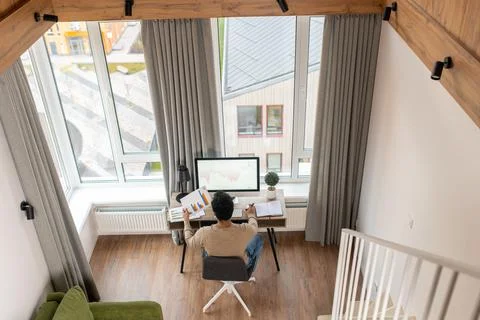 Focused hindu freelancer guy using computer in contemporary office space Stock Photos