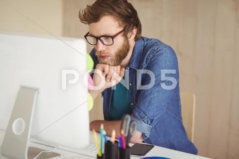 Focused hipster working at his desk Stock Photos