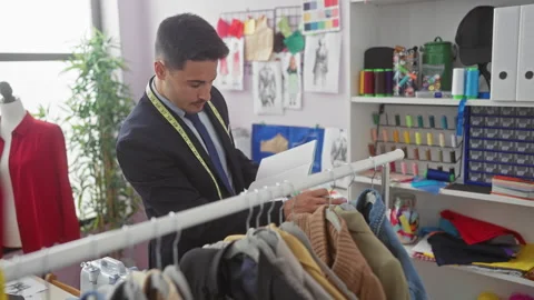 A focused hispanic man with a beard working in a colorful tailor shop, surr.. Stock Footage 274704811