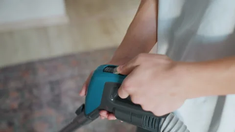 Focused home maintenance using ergonomic vacuum handle. Detail shot of homeowner Vidéo 342336433