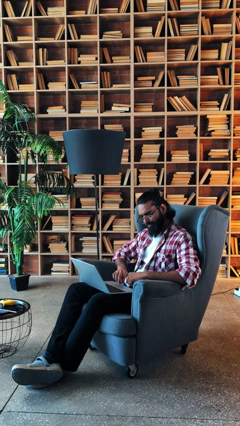 Focused Indian freelancer typing on laptop in library, working on big project Stock Footage 316839191
