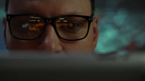 A focused individual analyzing data on a computer screen in a dimly lit work Stock Footage 323723923