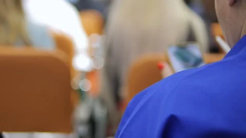 A Focused Individual Dressed in Blue Attire Engaged in Using a Mobile Stock Footage 284908277