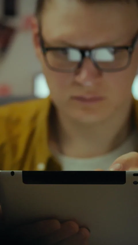 Focused individual engaged in technology using portable device in immersive Stock Footage 331582670