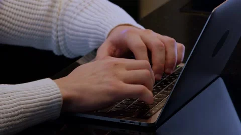 A focused individual types on a laptop in a creative workspace Vidéo 285322045