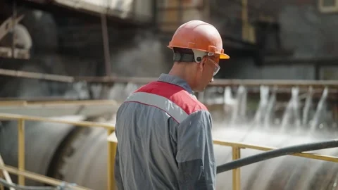 Focused industrial worker monitors large machinery at a manufacturing plant Stock Footage 274490214