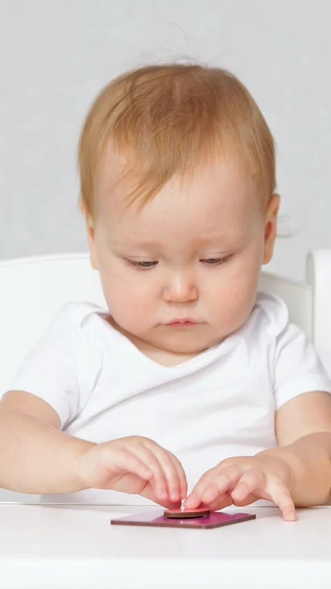 Focused infant developing fine motor skills with montessori puzzle. Adorable Video stock 341285249