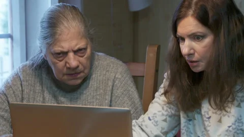 Focused Intergenerational Collaboration: Mother and Daughter on Computer Indoors Stock Footage 321155570