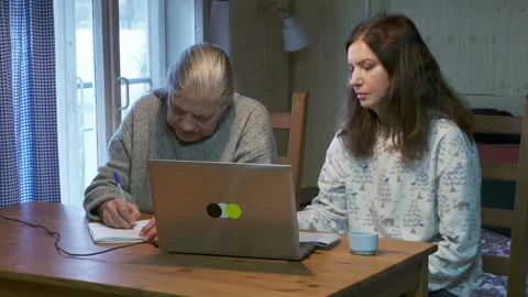 Focused Intergenerational Learning: Daughter Guiding Mother in Computer Use Stock Footage 321148188