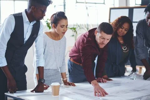 Focused on interpreting the space. a team of professionals working on blueprints Stock Photos