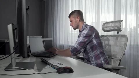 Focused IT professional immersed in dual-screen project work Video stock 311674545