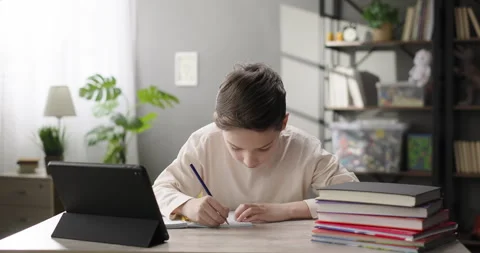 Focused kid studying online using digital tablet, learning at virtual lesson Stock Footage 264805247