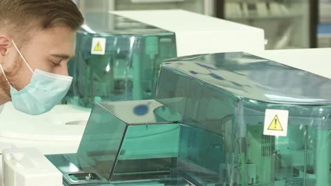 Focused laboratory assistant intently observes the centrifuge in action Stock Footage 311945596