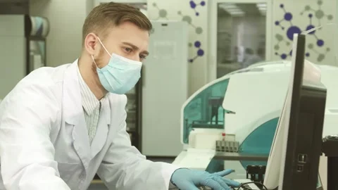 Focused laboratory worker analyzes test results on a computer Stock Footage 311951374