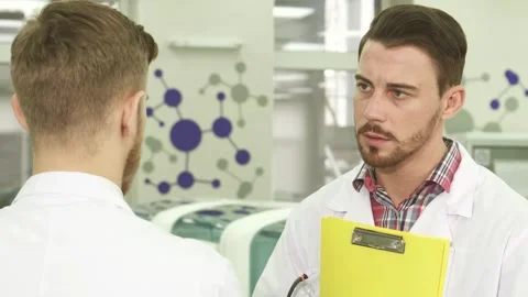 Focused laboratory workers engage in serious discussions about their research Stock Footage 311991984