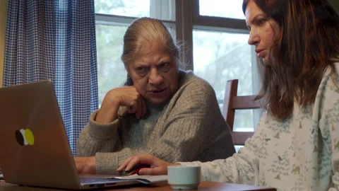 Focused Learning: Elderly Mother Earnestly Learns Computer Skills from Daughter. Stock Footage 320326064