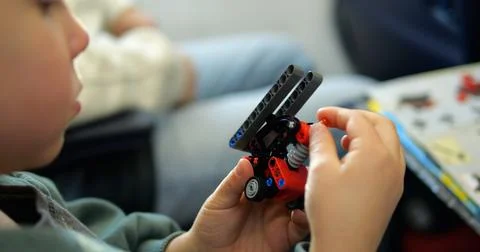 Focused little boy assembles toy of construction set details in airplane cabin Stock Photos
