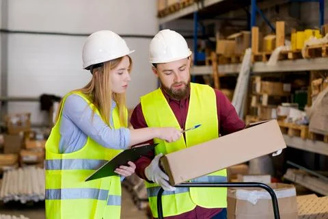 Focused logistics team verifying shipment contents together 库存照片