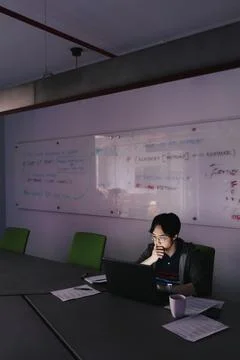 Focused male computer programmer working late at laptop in office Stock-Fotos