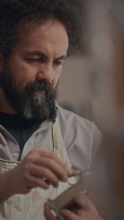 Focused Male Painter Applying Fast Palette Knife Strokes to Canvas Stock Footage 330883288