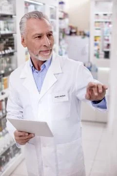 Focused male pharmacist correcting data Stock Photos