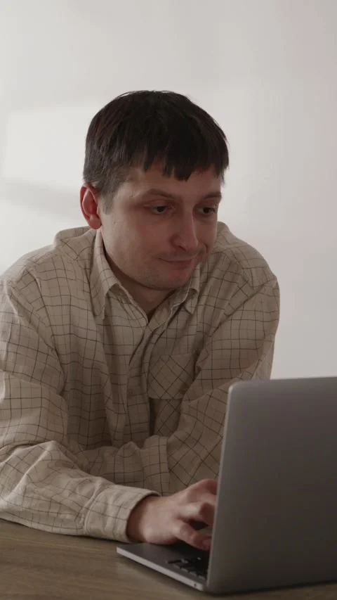 Focused male programmer leaning forward looking at laptop screen close up Stock Footage 335082373