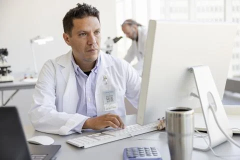 Focused male scientist working at computer in laboratory Foto stock