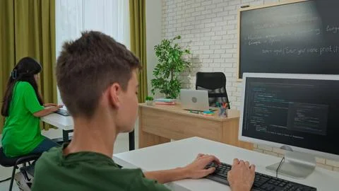 Focused Male Student Programming on Computer in Classroom Stock Photos