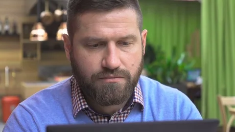 Focused man browsing tablet computer, portrait, in pub, cafe, close steadicam. Vidéo 73066980
