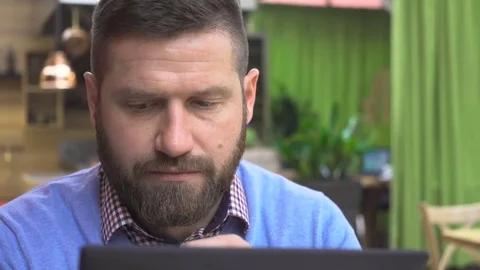 Focused man browsing tablet, look to camera portrait, cafe, pub, close steadicam Vídeo Stock 73067163