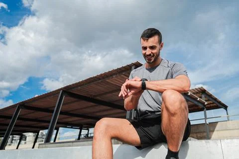 Focused man checking his smartwatch while engaged in an active training rou.. Stock Photos