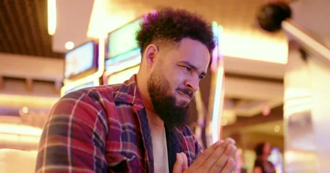 A focused man is deeply engaged and immersed in gaming activities at a vibrant Stock Footage 294829114