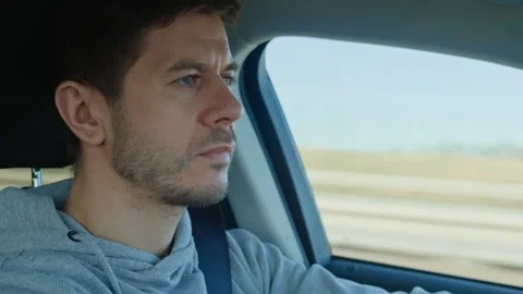 Focused man driving a car on the road, inside view 動画素材 303227904