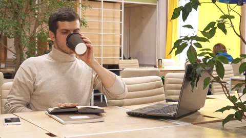 Focused man engrossed in reading at a modern coworking space Stock Footage 311944076