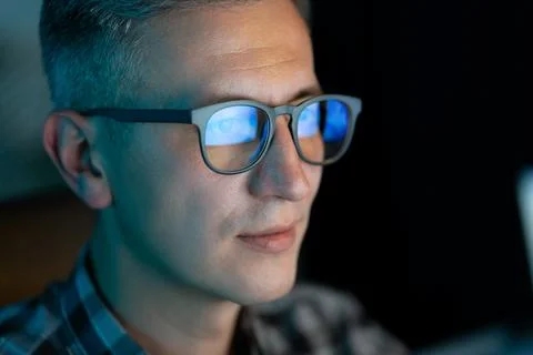 Focused Man With Glasses Working on Computer in Dark Room Stock Photos